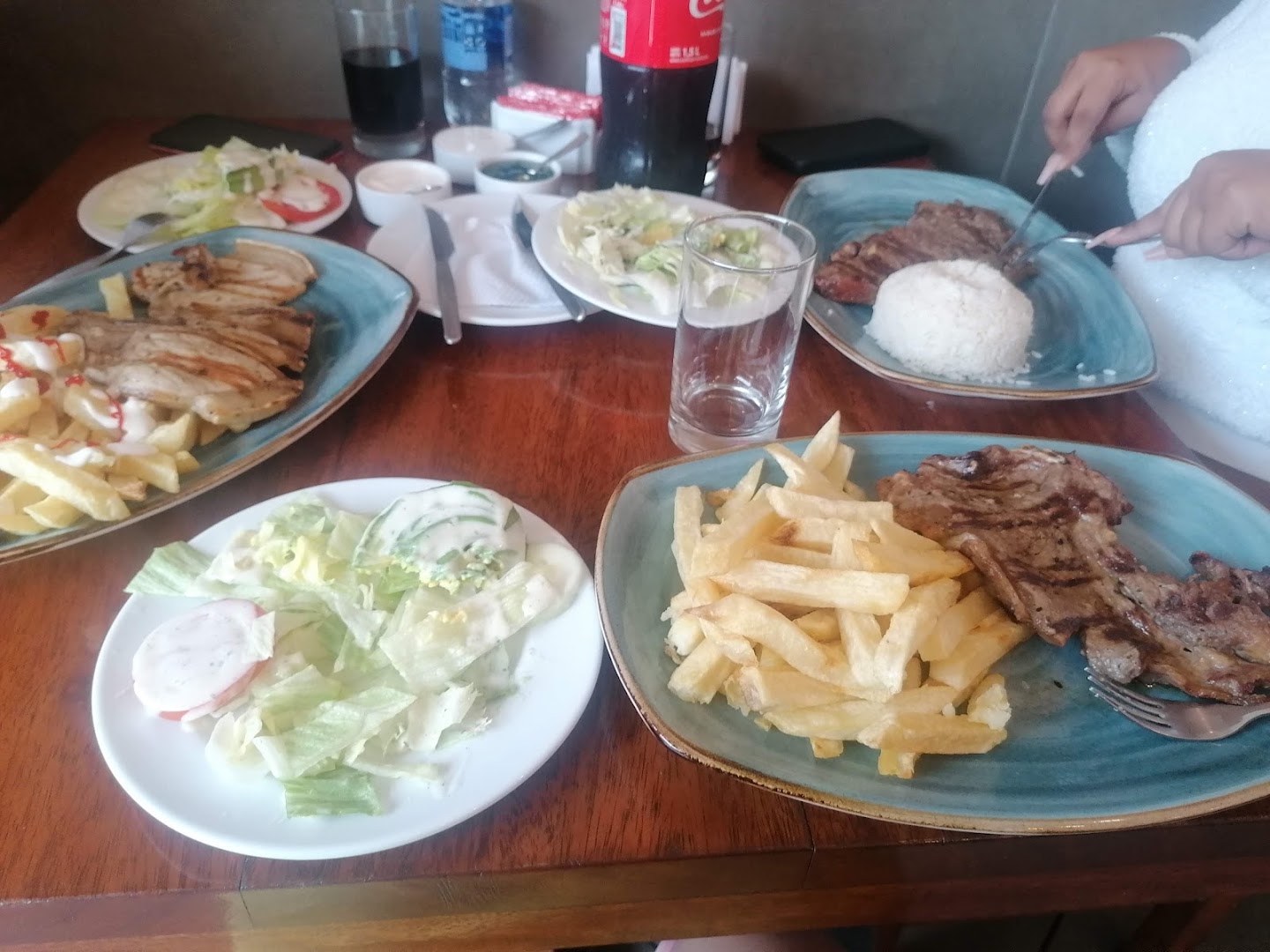 Mesa con variedad de platos — AlaCasa Pollos & Parrillas