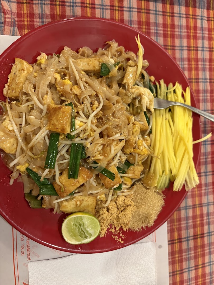 Pad thai servido en plato rojo