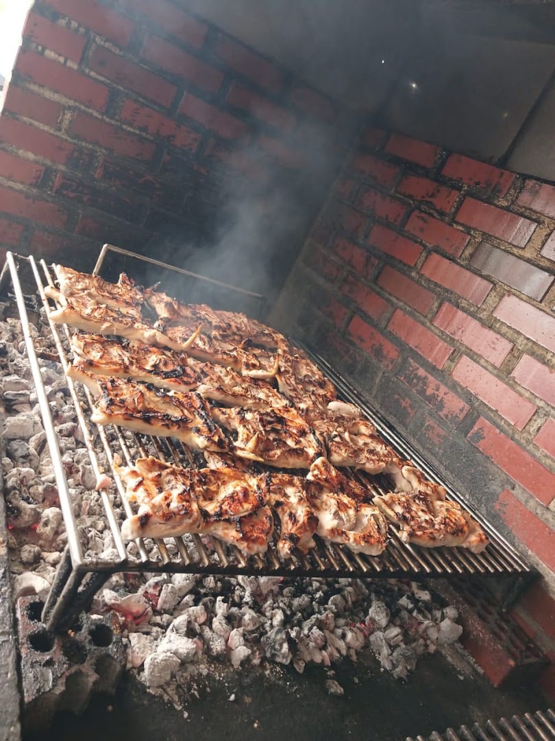 Pollo asado al carbon en la parrilla de brasas