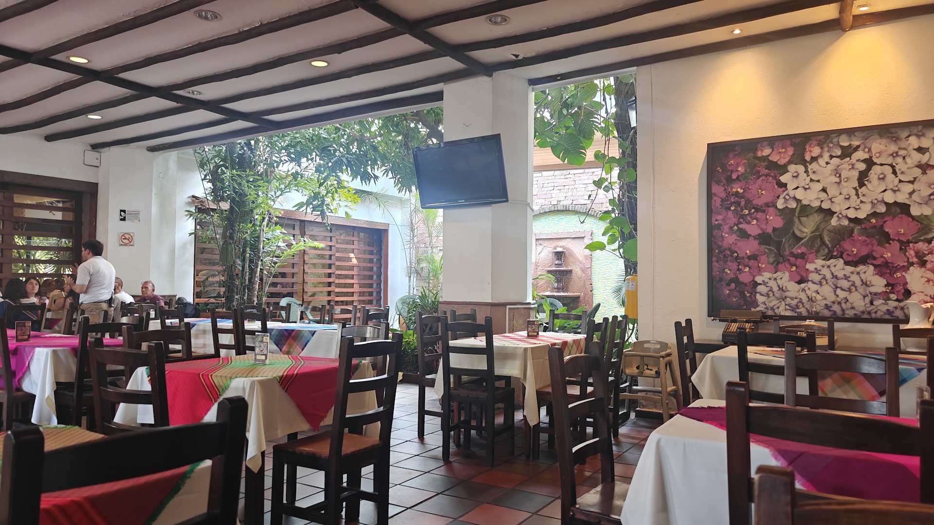 Terraza con mesas rojas — La Puerta del Sol Restaurante