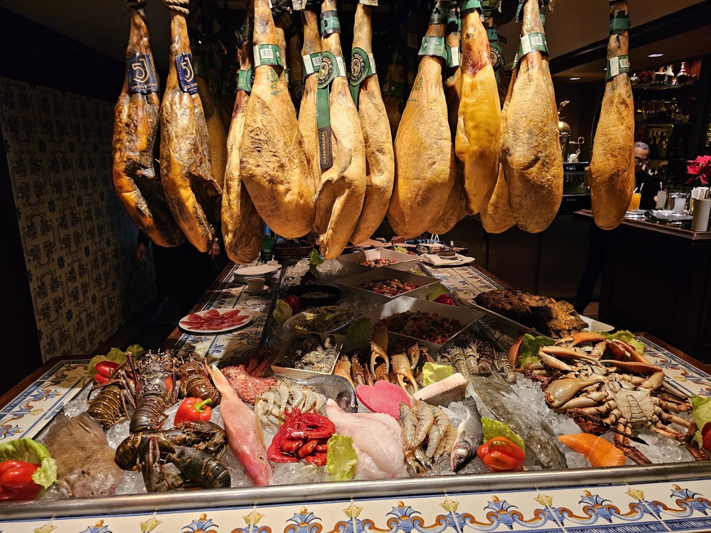 Jamones colgados junto a mariscos — Restaurante Don Pepe