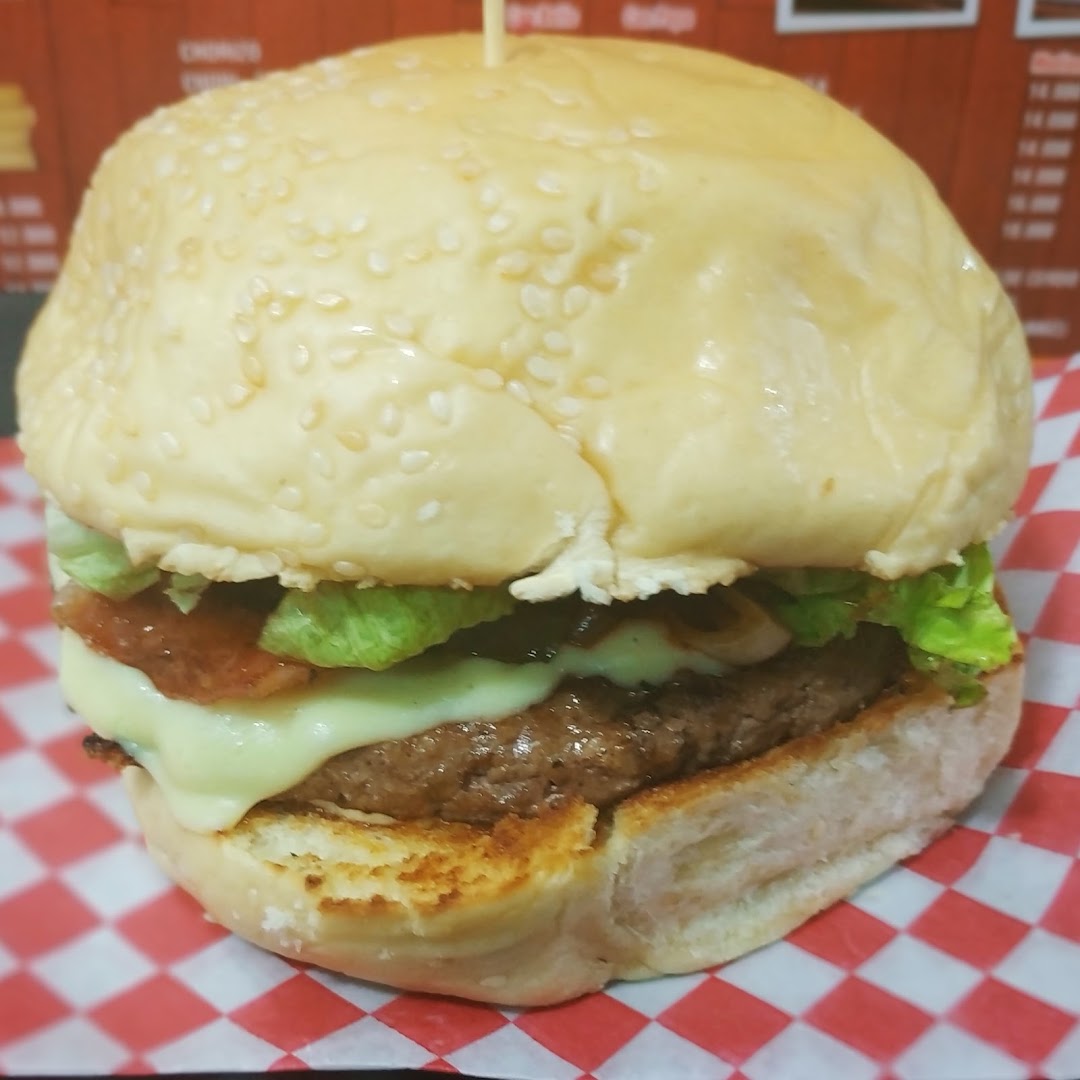 Hamburguesa con queso y lechuga sobre papel a cuadros
